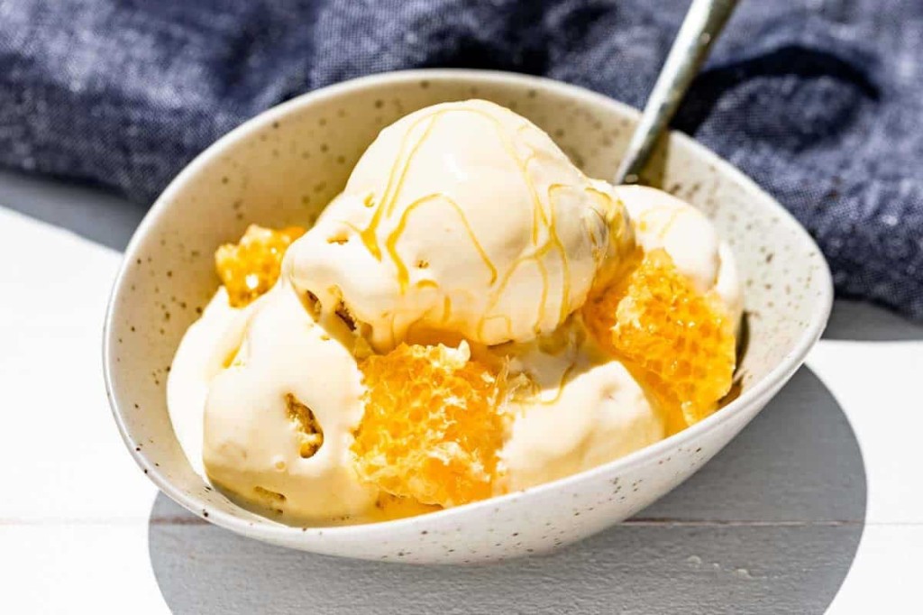 Honey ice cream with honeycomb in a speckled bowl